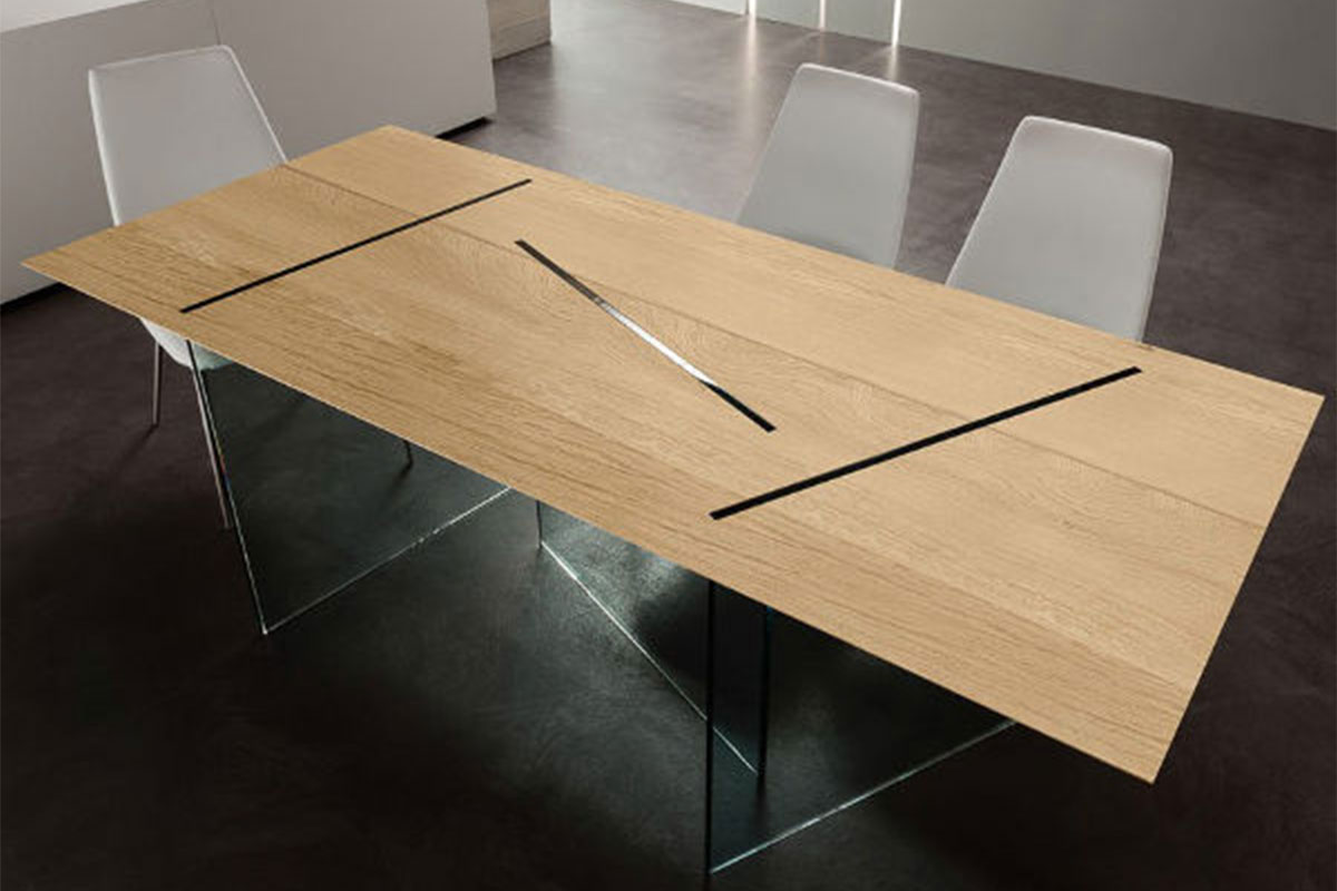 Tavolo rettangolare in legno massello con gambe in vetro.